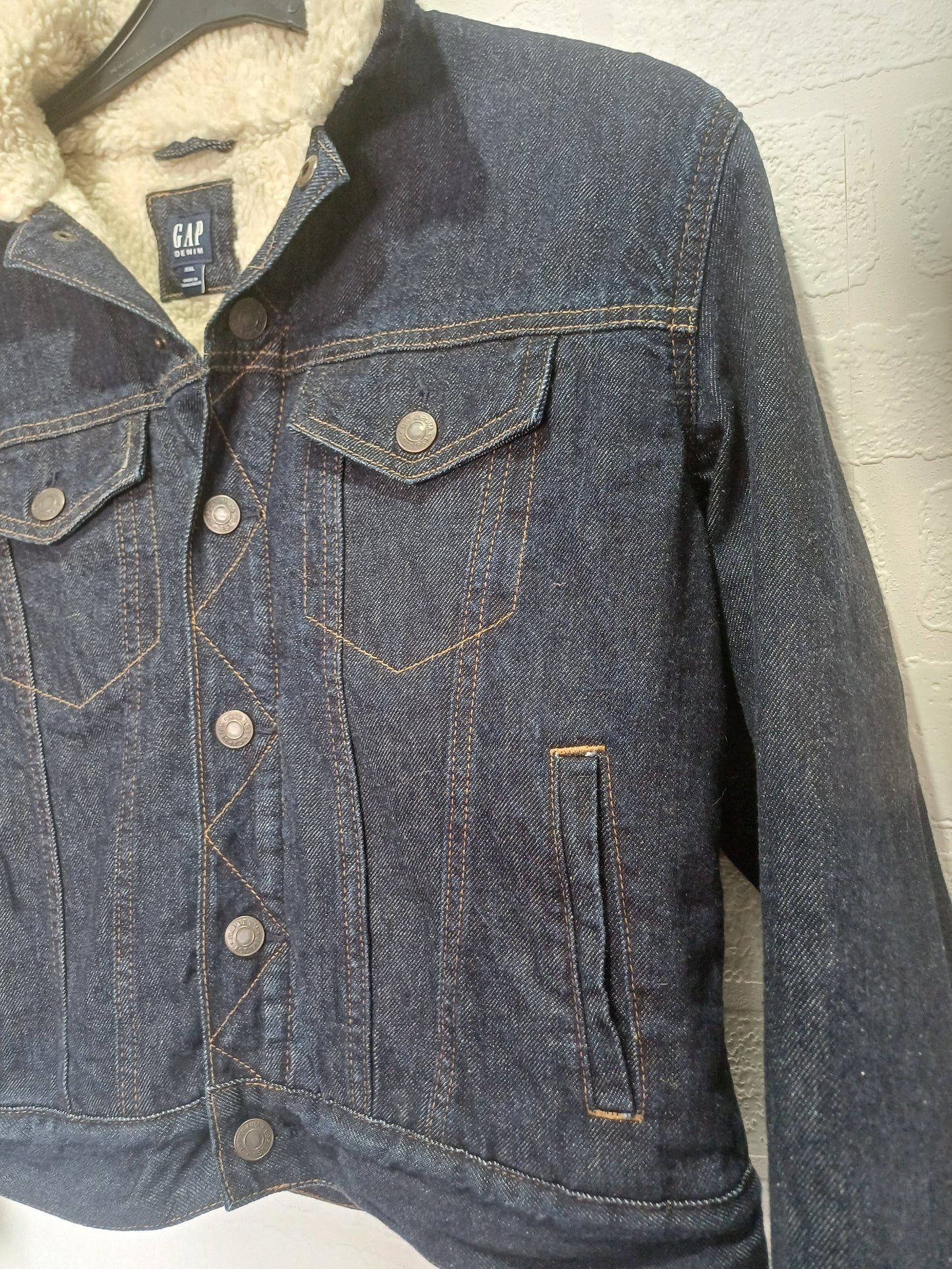 Close-up of blue jeans with stitching details on a light background