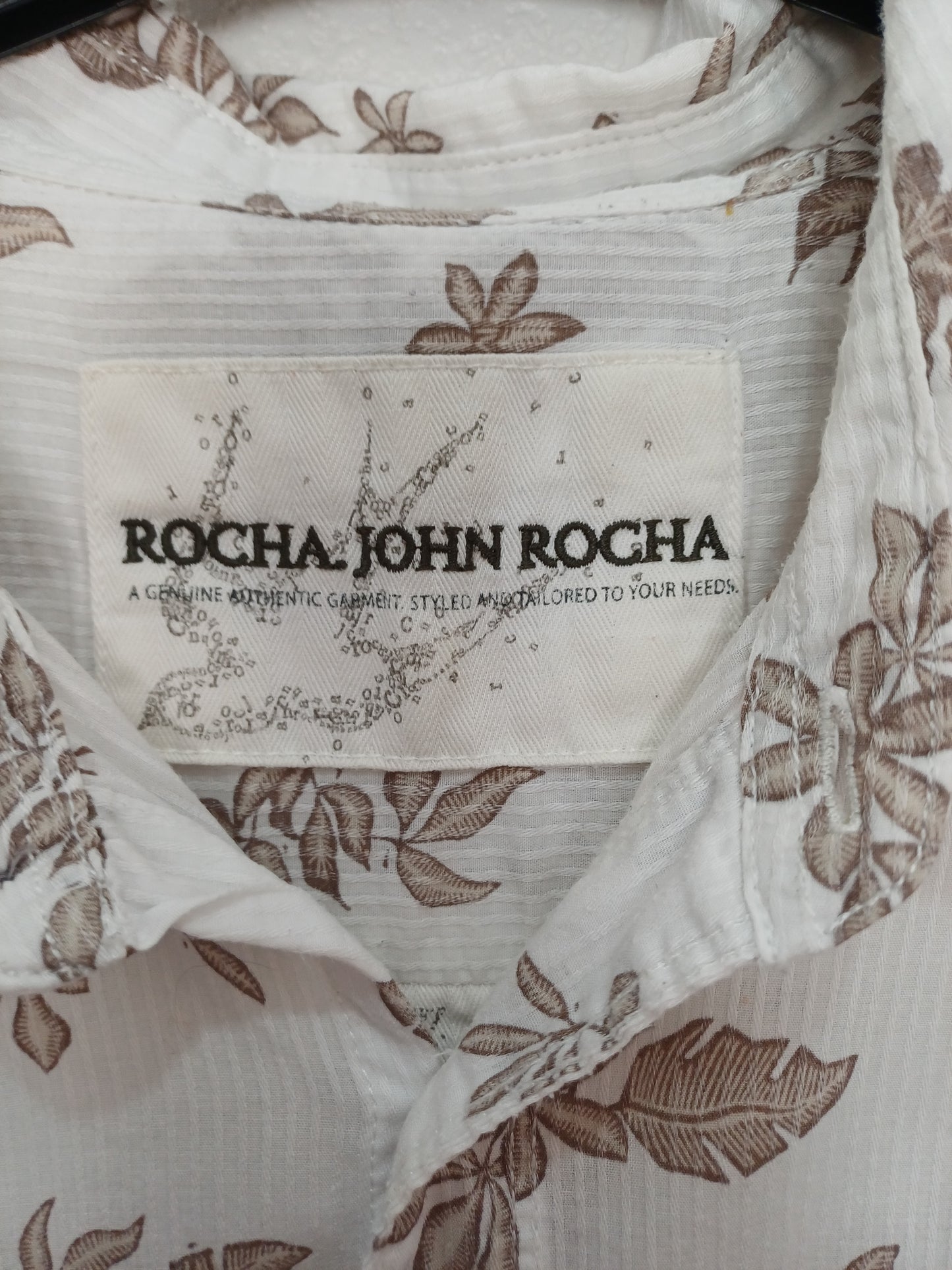 Close-up of a Rocha John Rocha label on a garment with floral patterns.