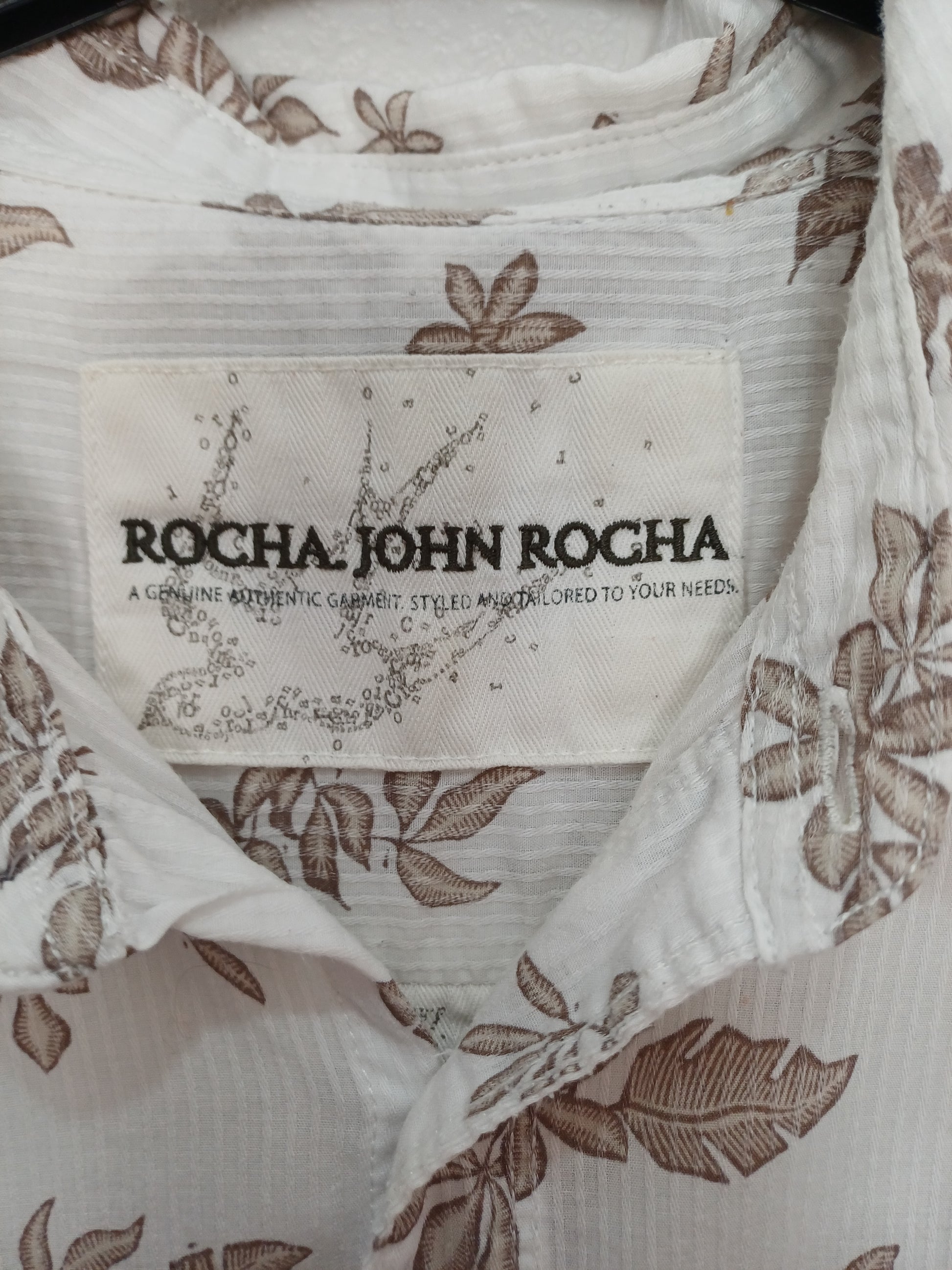 Close-up of a Rocha John Rocha label on a garment with floral patterns.