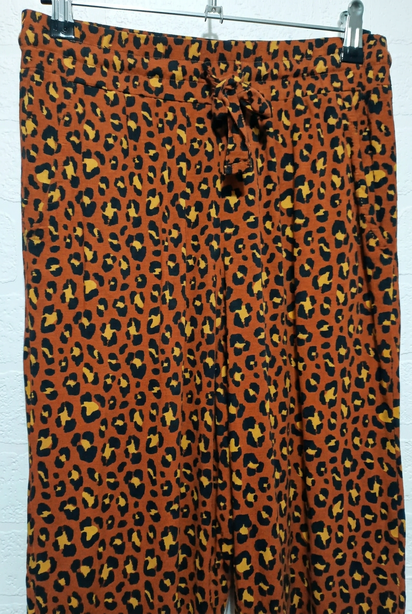 Detail view of brown leopard print trousers